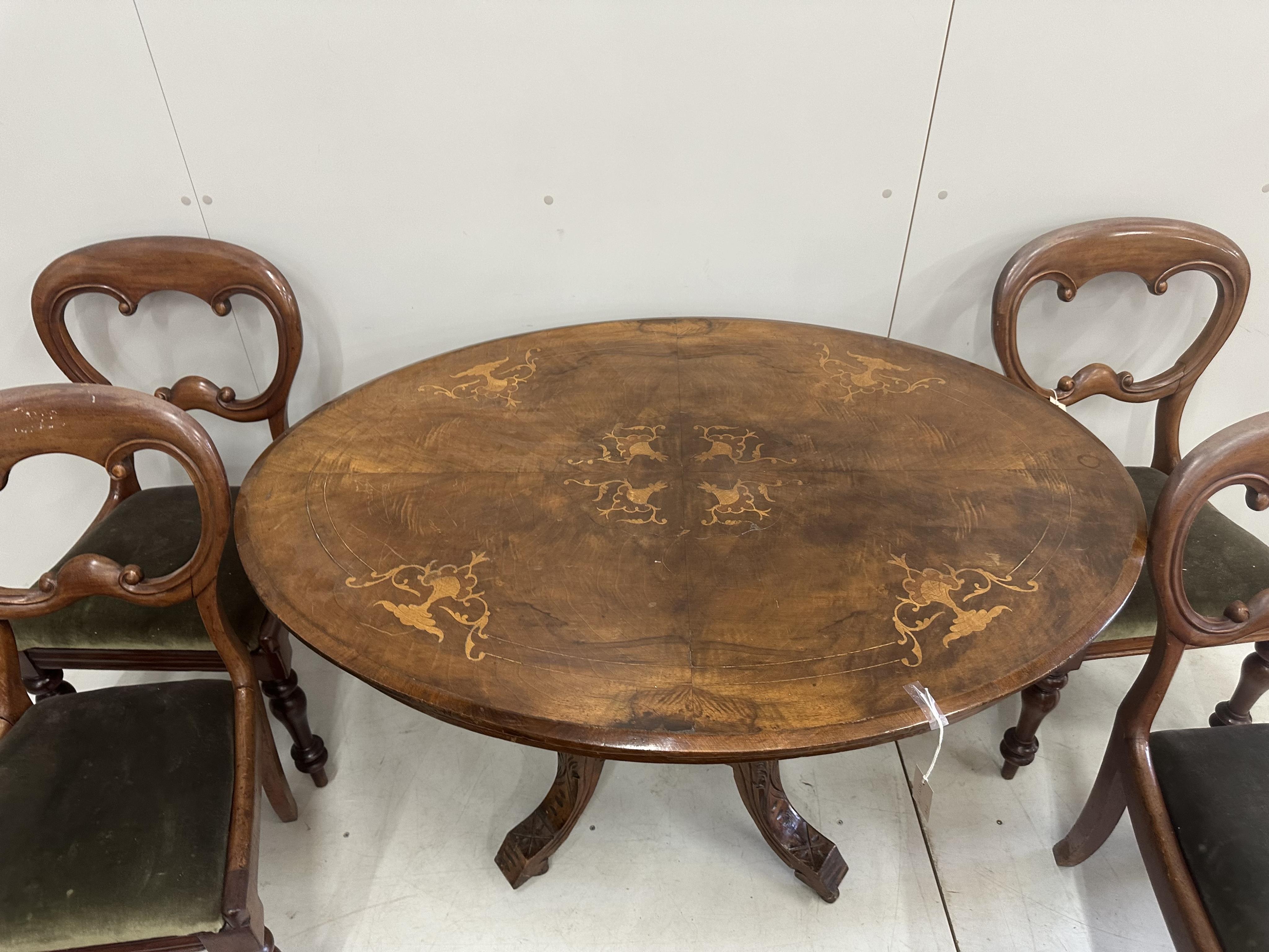 A Victorian inlaid walnut oval loo table, width 120cm, depth 86cm, height 72cm, lacks bolts together with four Victorian mahogany balloon back dining chairs. Condition - poor to fair